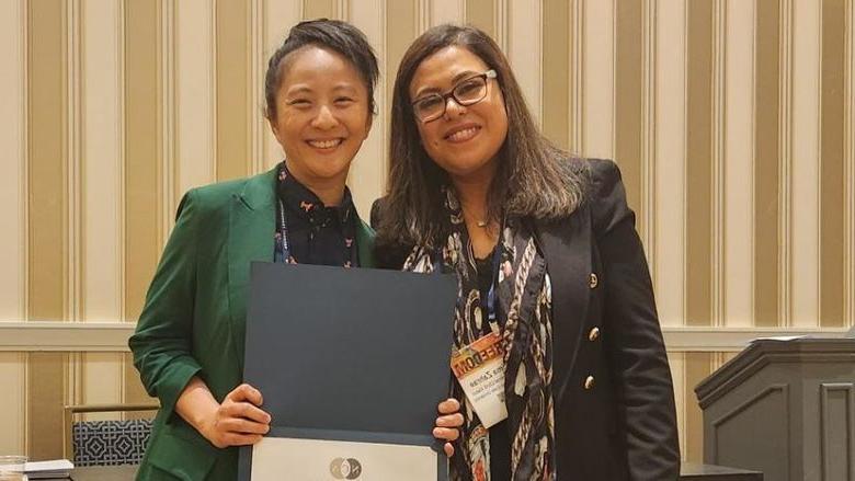 Terrie Wong holding certificate next to woman at National Communication Association conference