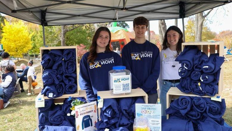 students selling THON sweatshirts